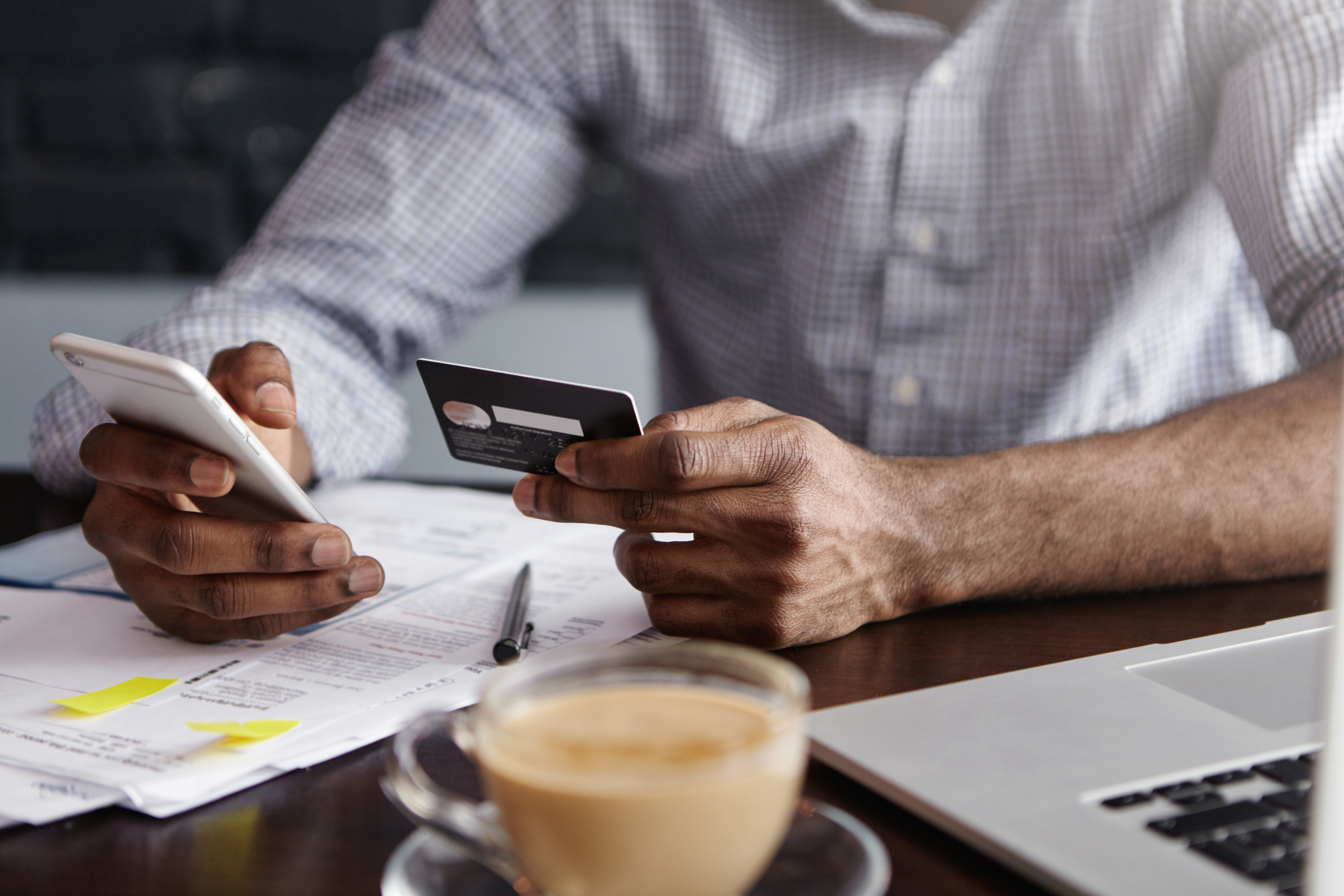 A man holding a bank card and a phone | Source: Shutterstock