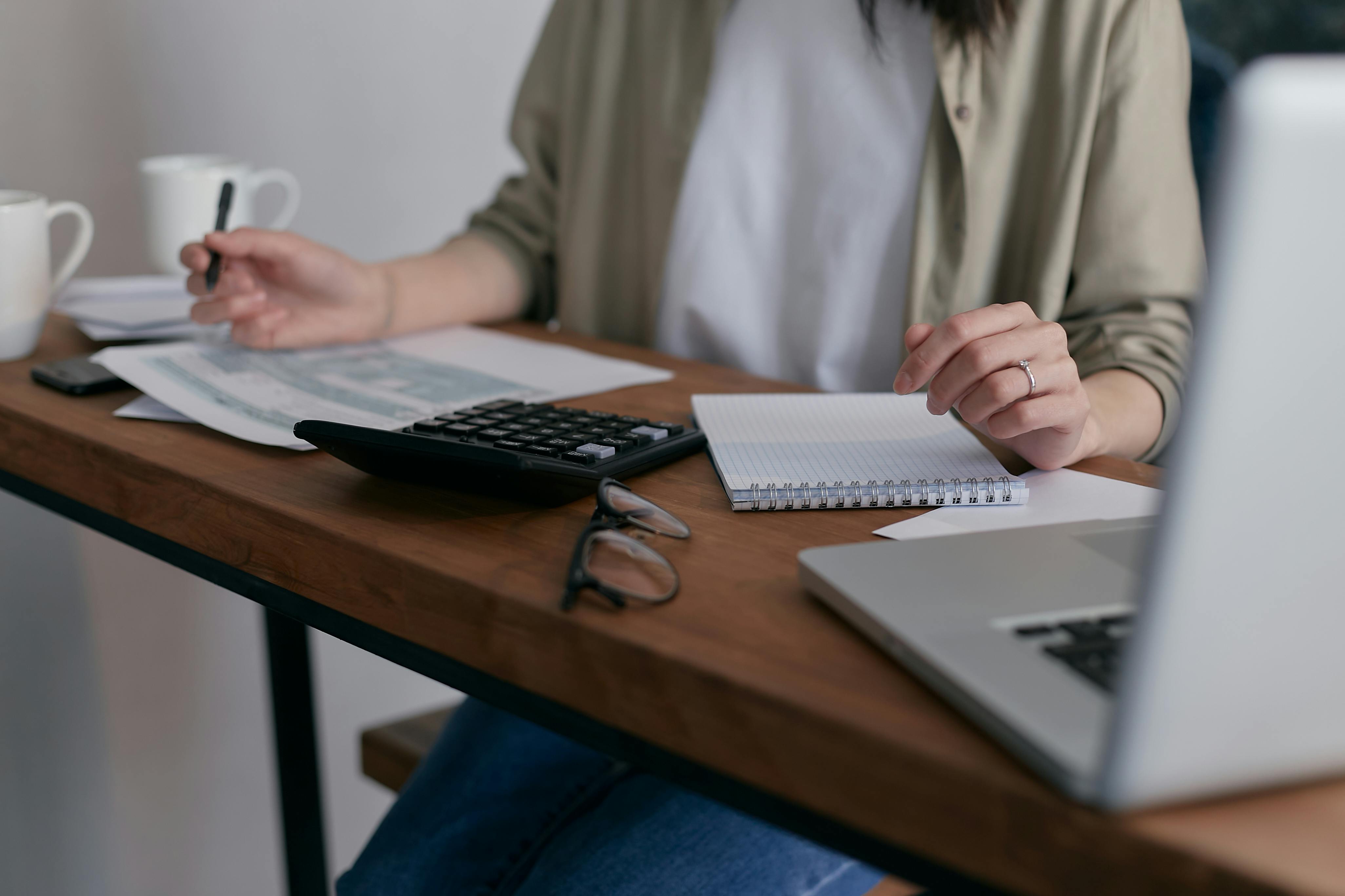 Calculator and laptop on a desktop | Source: Pexels