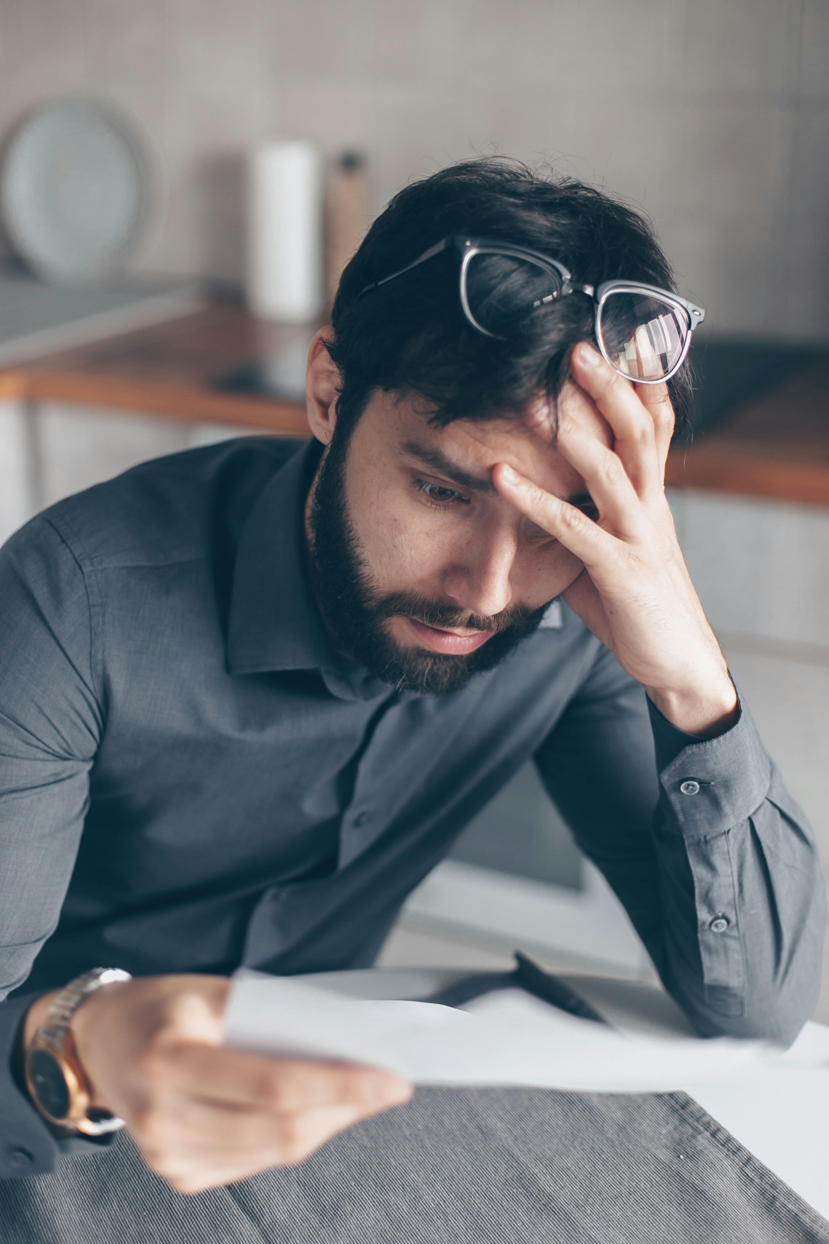 Confused man looking at a piece of paper | Source: Pexels