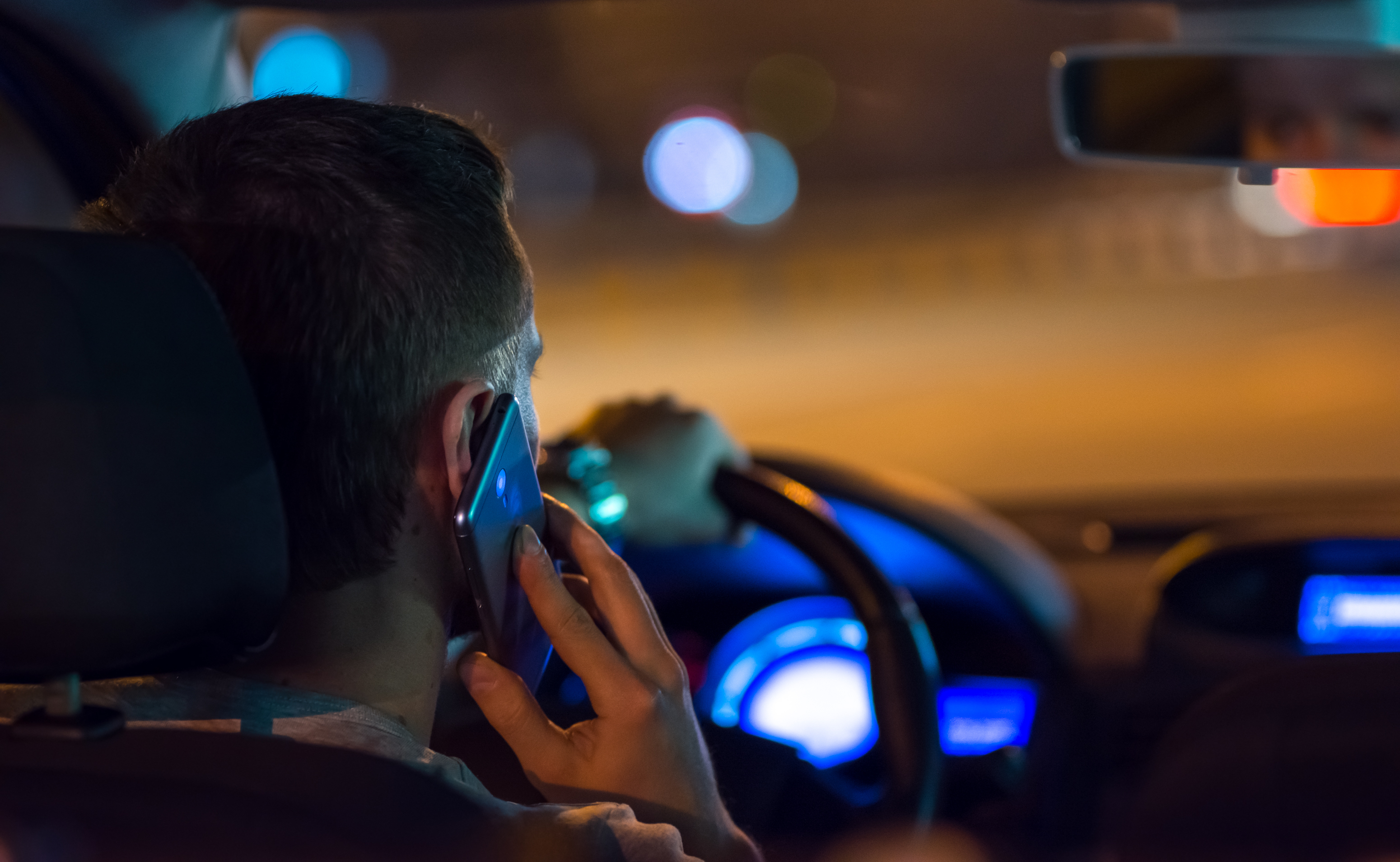 The man drive a car in the city and phone. | Source: Shutterstock