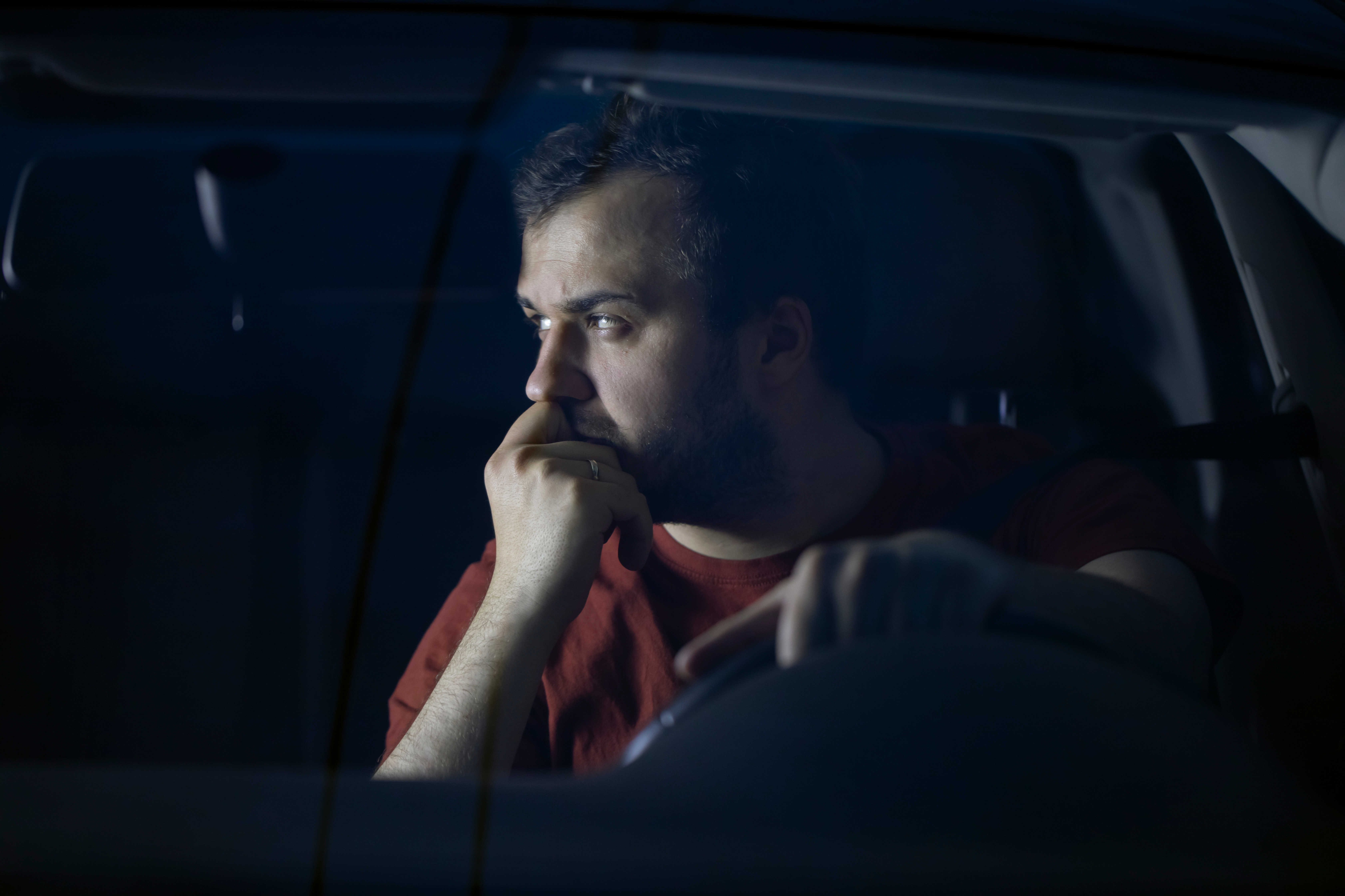 Sad depressed man spending time alone at car thinking about problems feeling lonely. | Source: Shutterstock