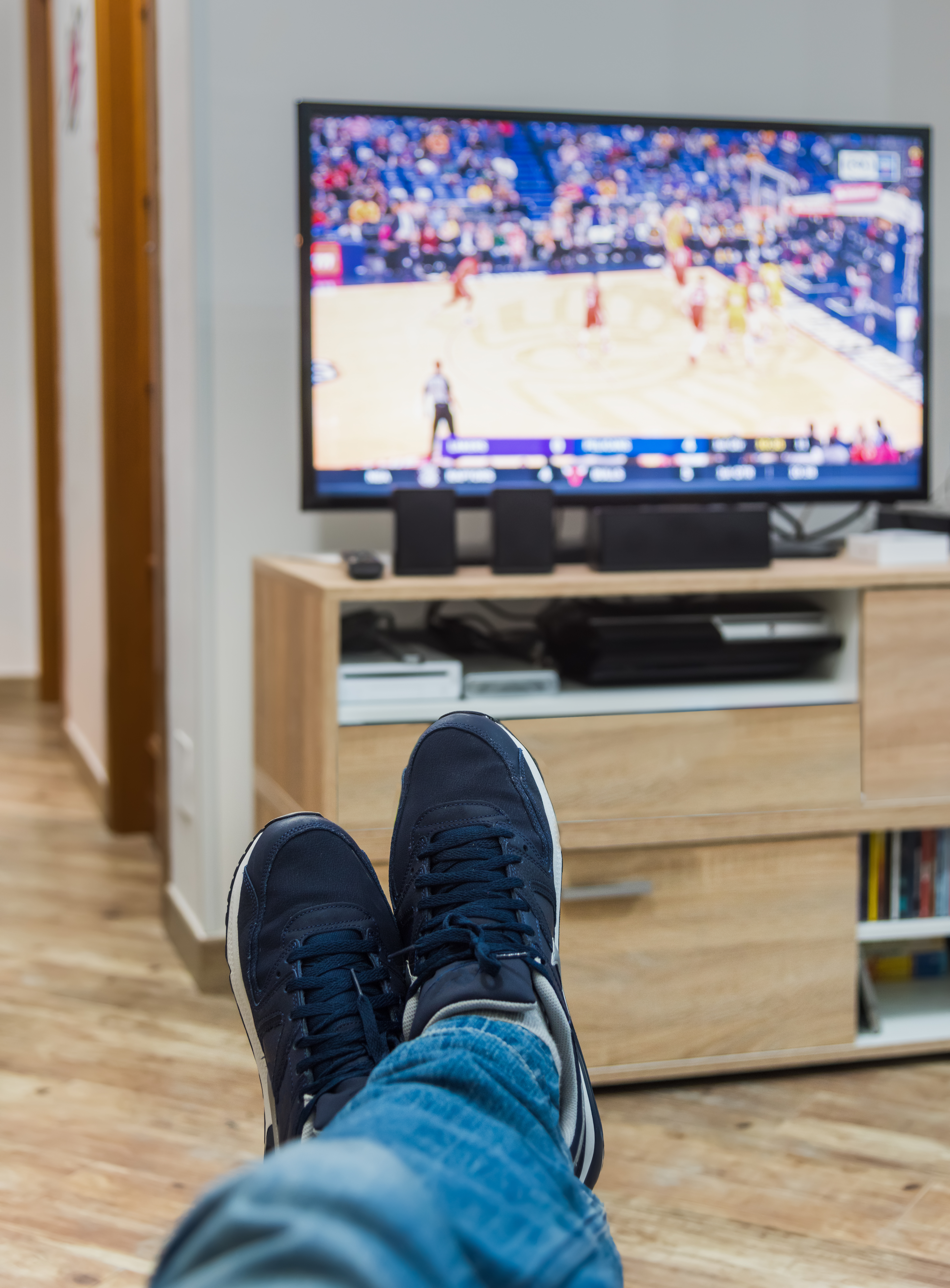 First person view of a man watching a basketball game on tv. | Source: Shutterstock