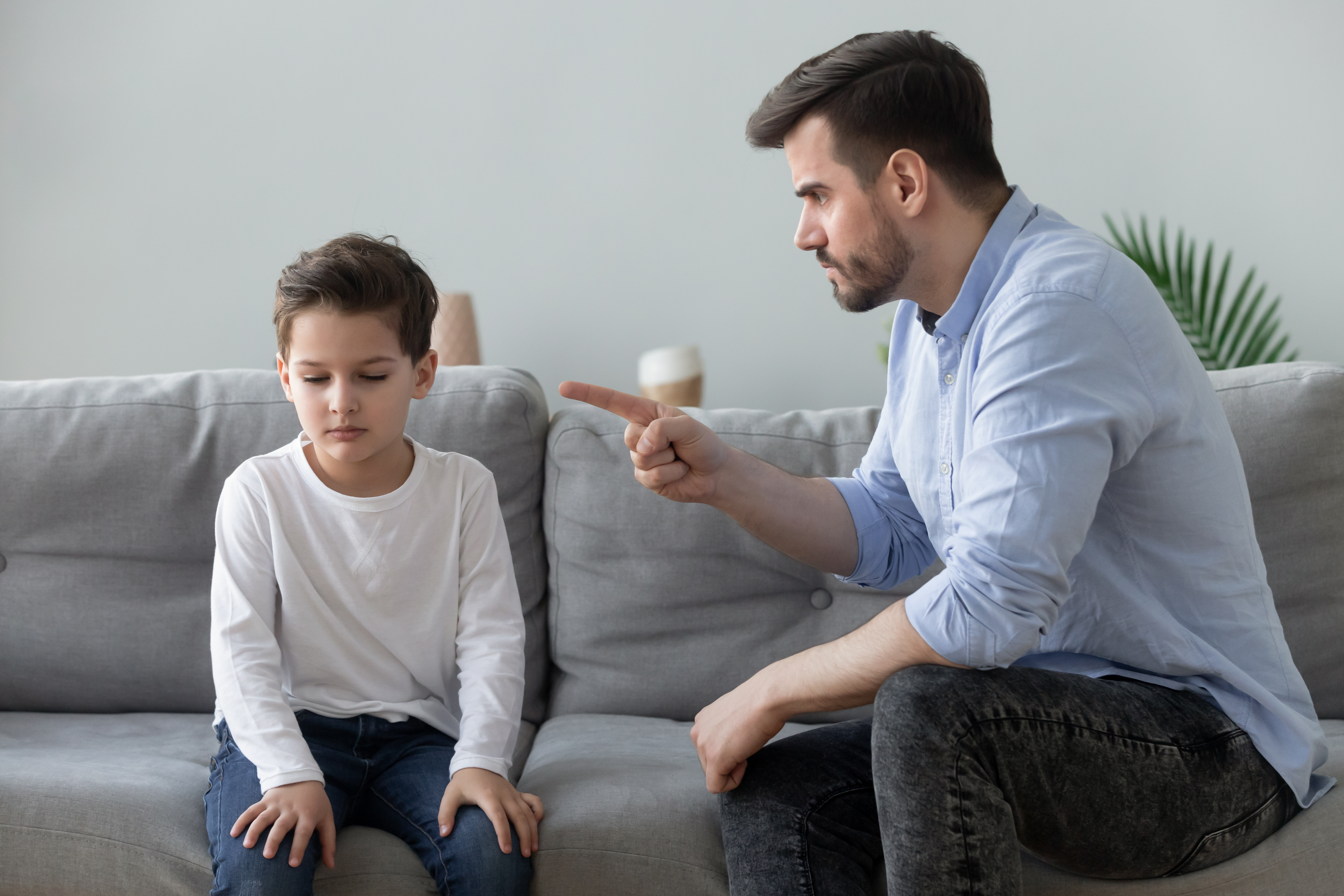 An angry man scolding a young child | Source: Shutterstock