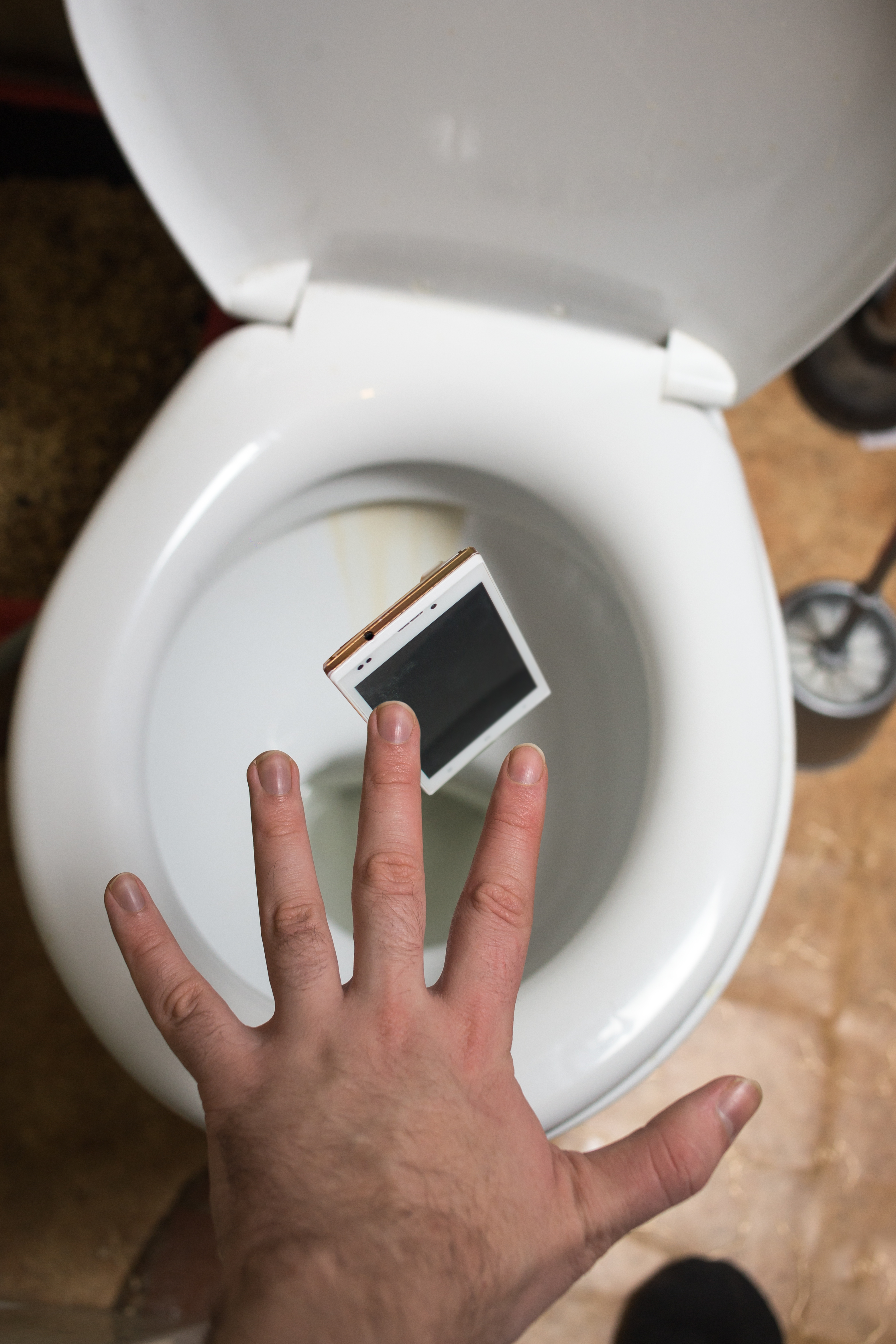 Man accidentally throws smartphone into toilet. | Source: Shutterstock