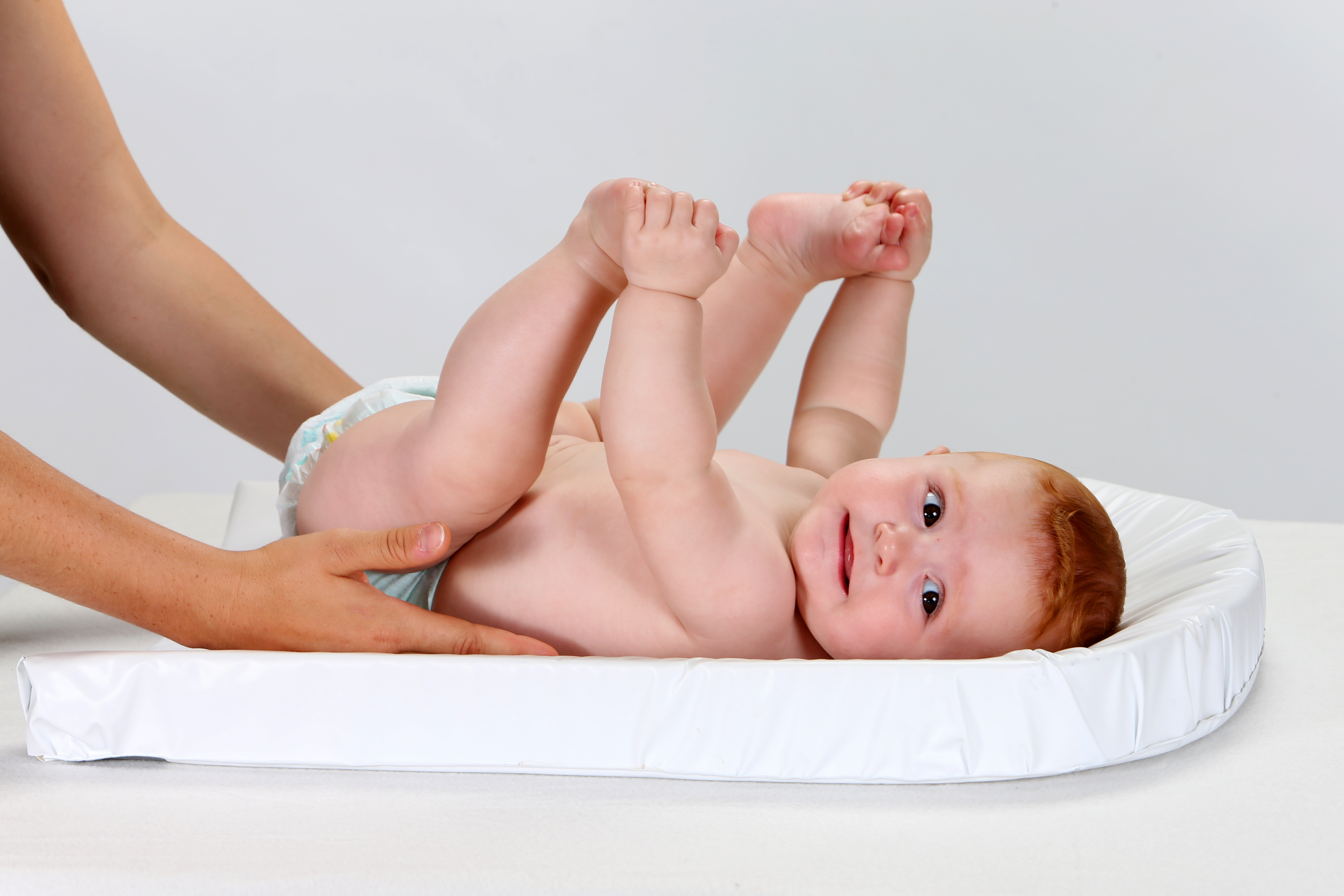 A woman holding a baby in a diaper | Source: Shutterstock