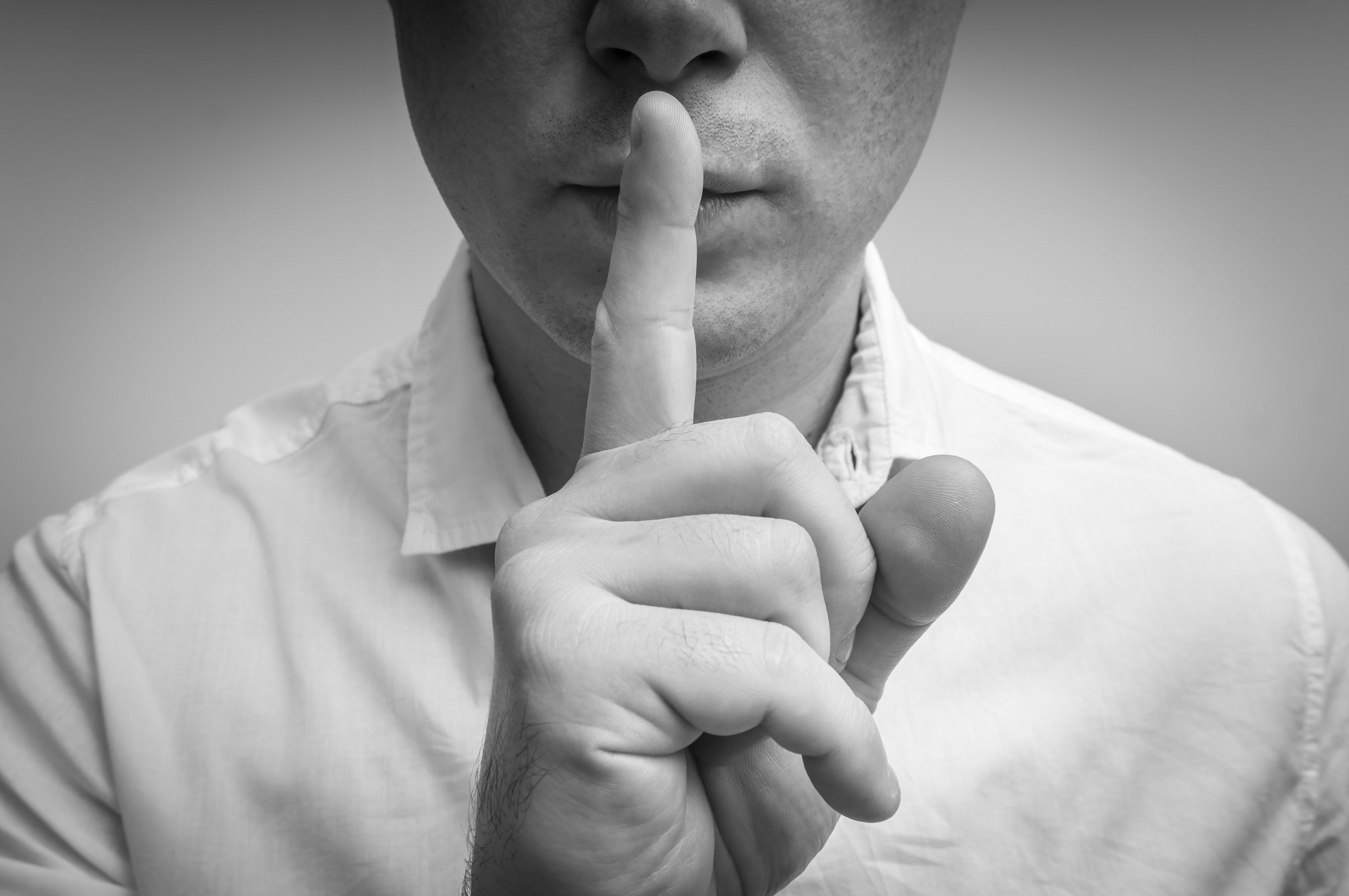 A man with his finger on his lips | Source: Shutterstock