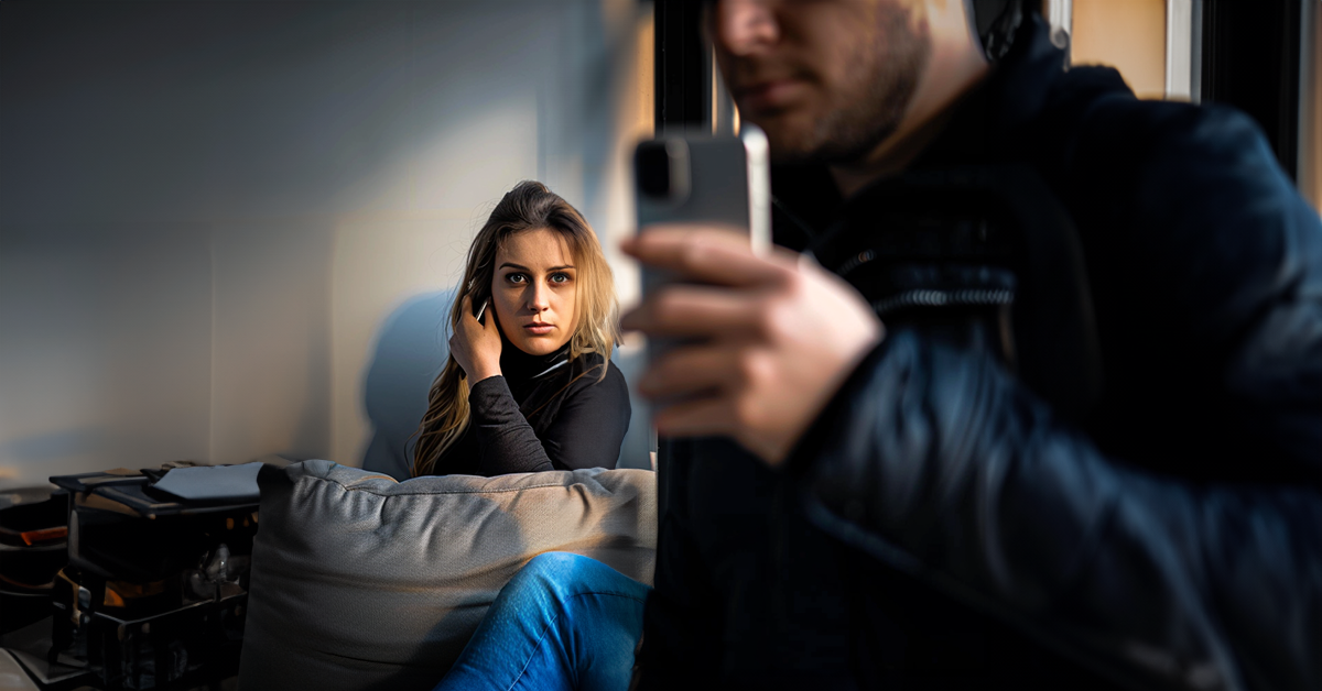 Woman spying behind a man with a phone | Source: Shutterstock