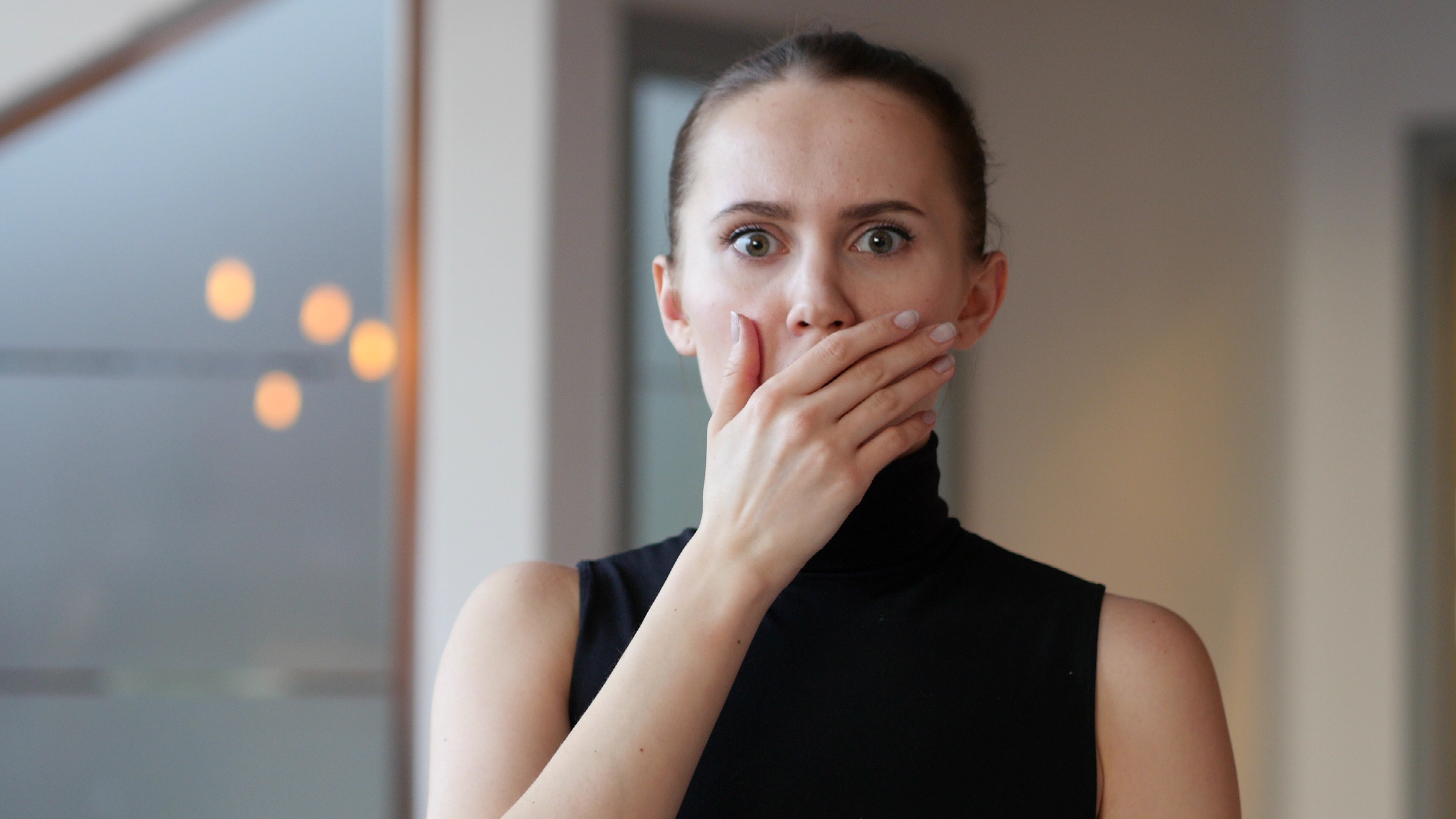 A shocked woman covering her mouth with her hand | Source: Shutterstock