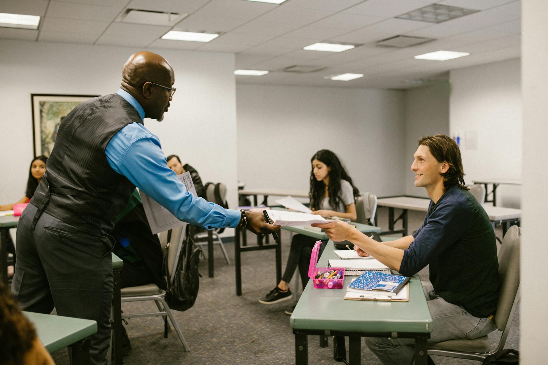 A teacher giving a student a paper | Source: Pexels