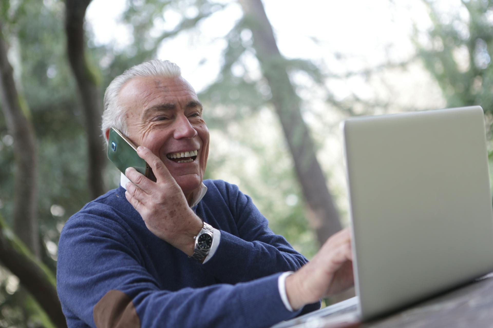 Man talking on the phone and typing on a computer | Source: Pexels