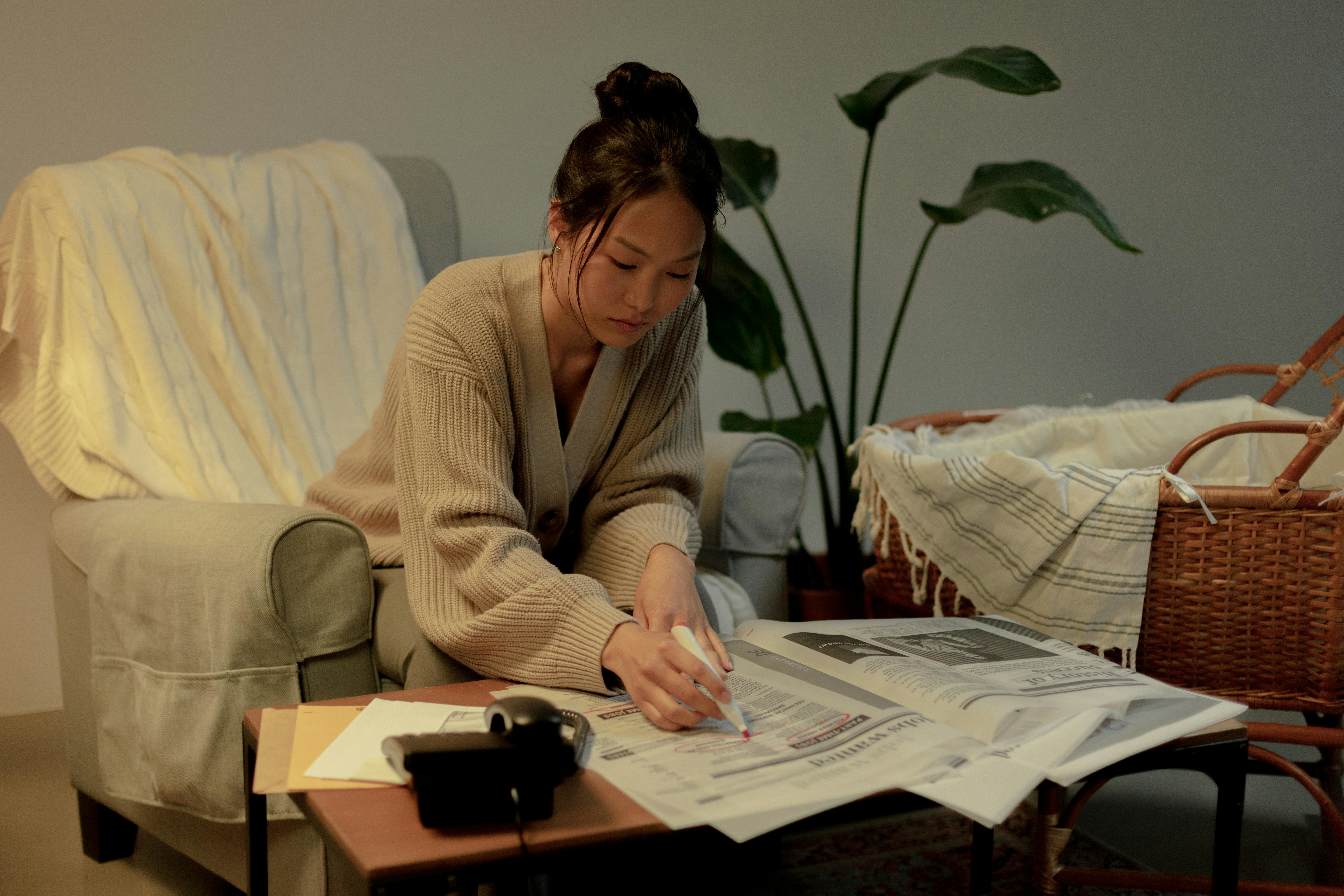 Woman looking for a job in the newspaper | Source: Pexels
