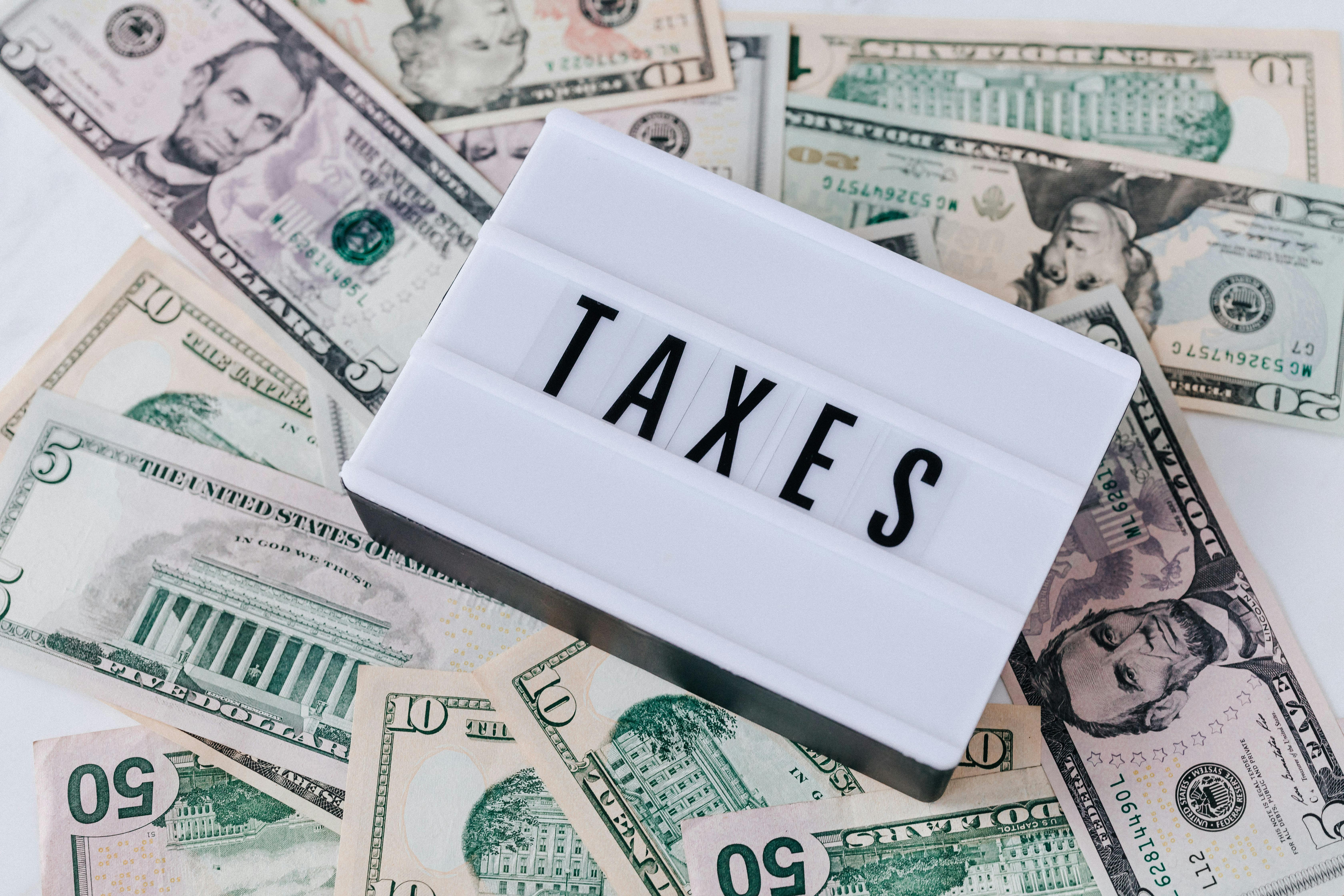 "Taxes" sign on dollar bills | Source: Pexels