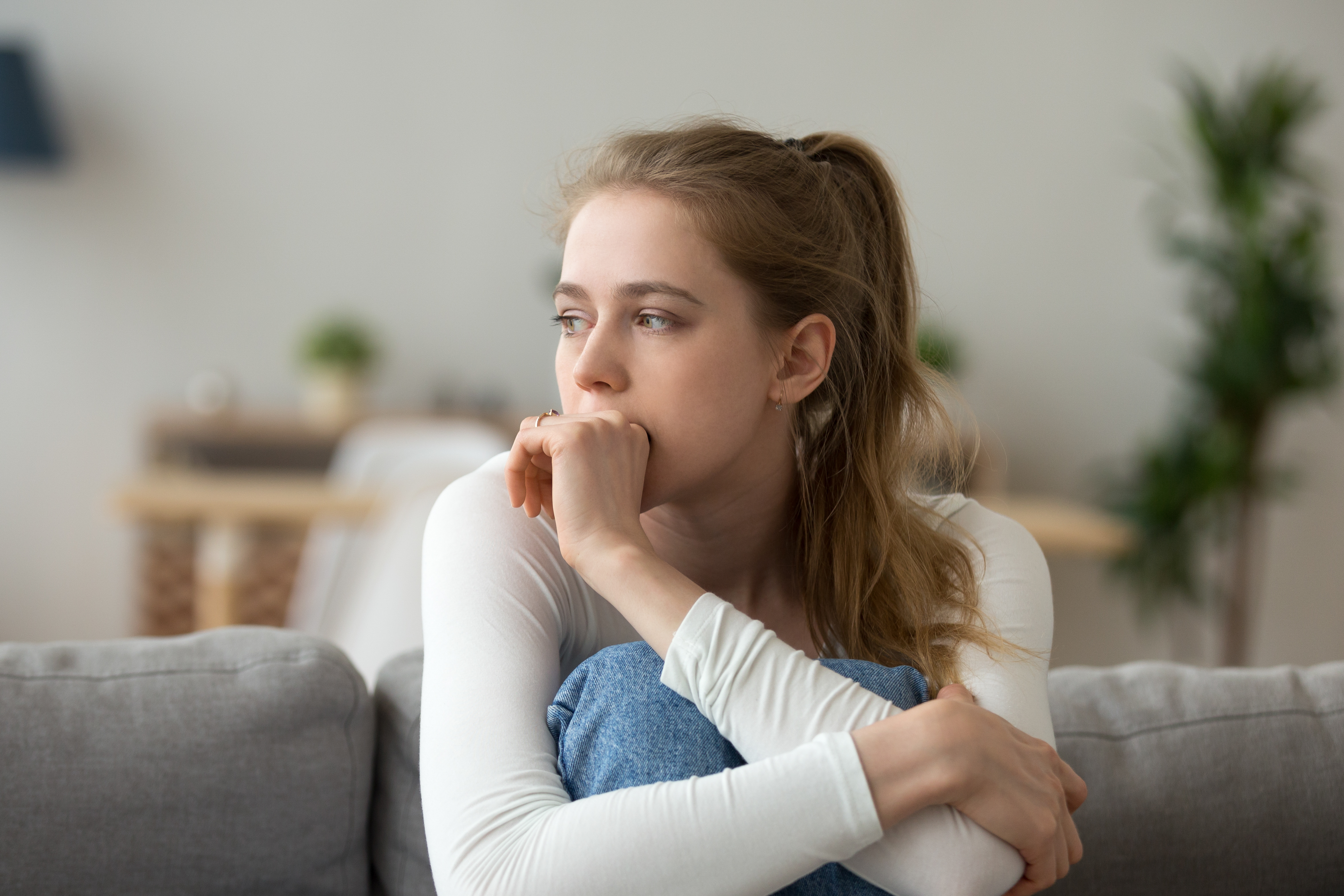 A young girl sitting on a couch | Source: Shutterstock