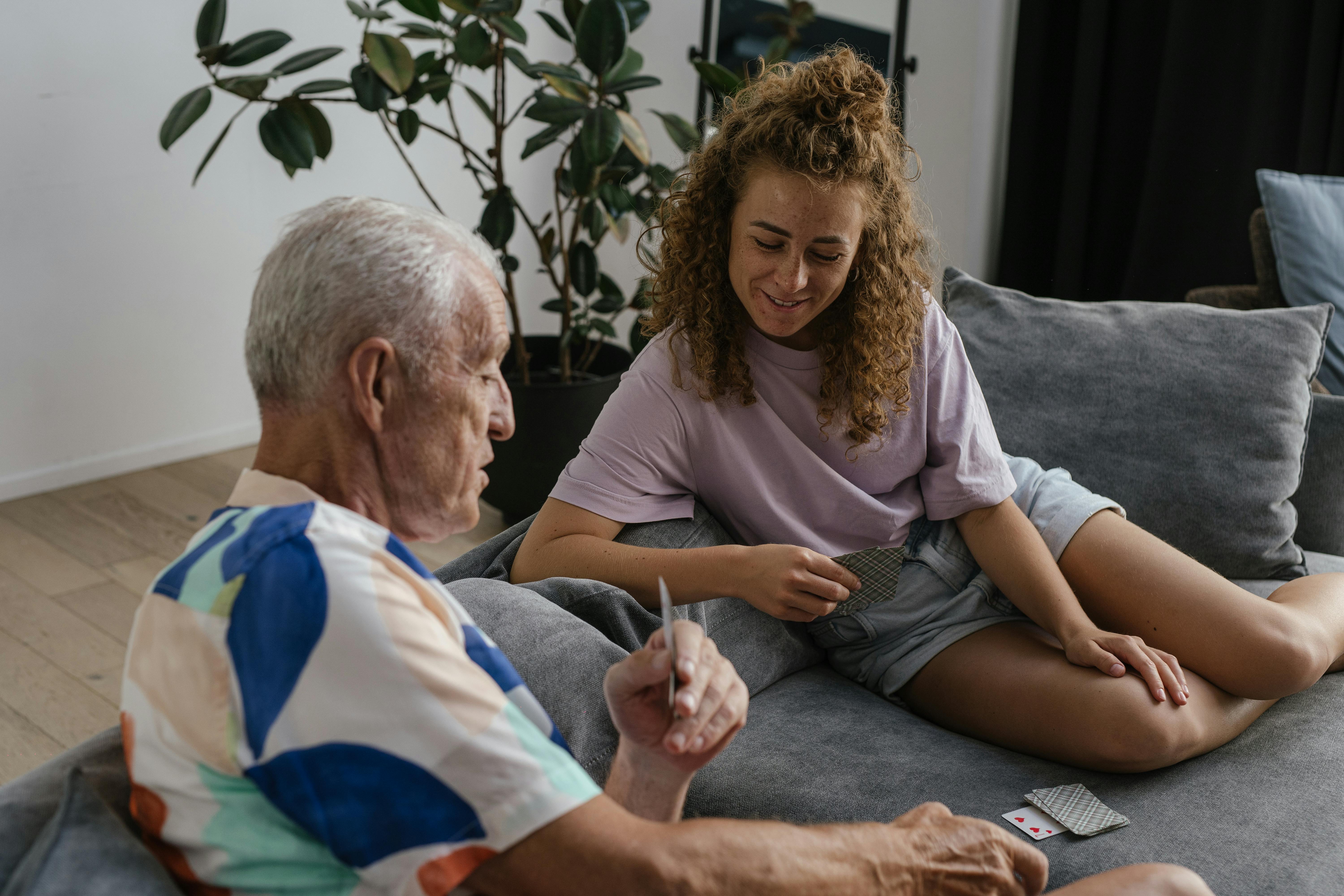 Old man and young woman playing cards | Source: Pexels