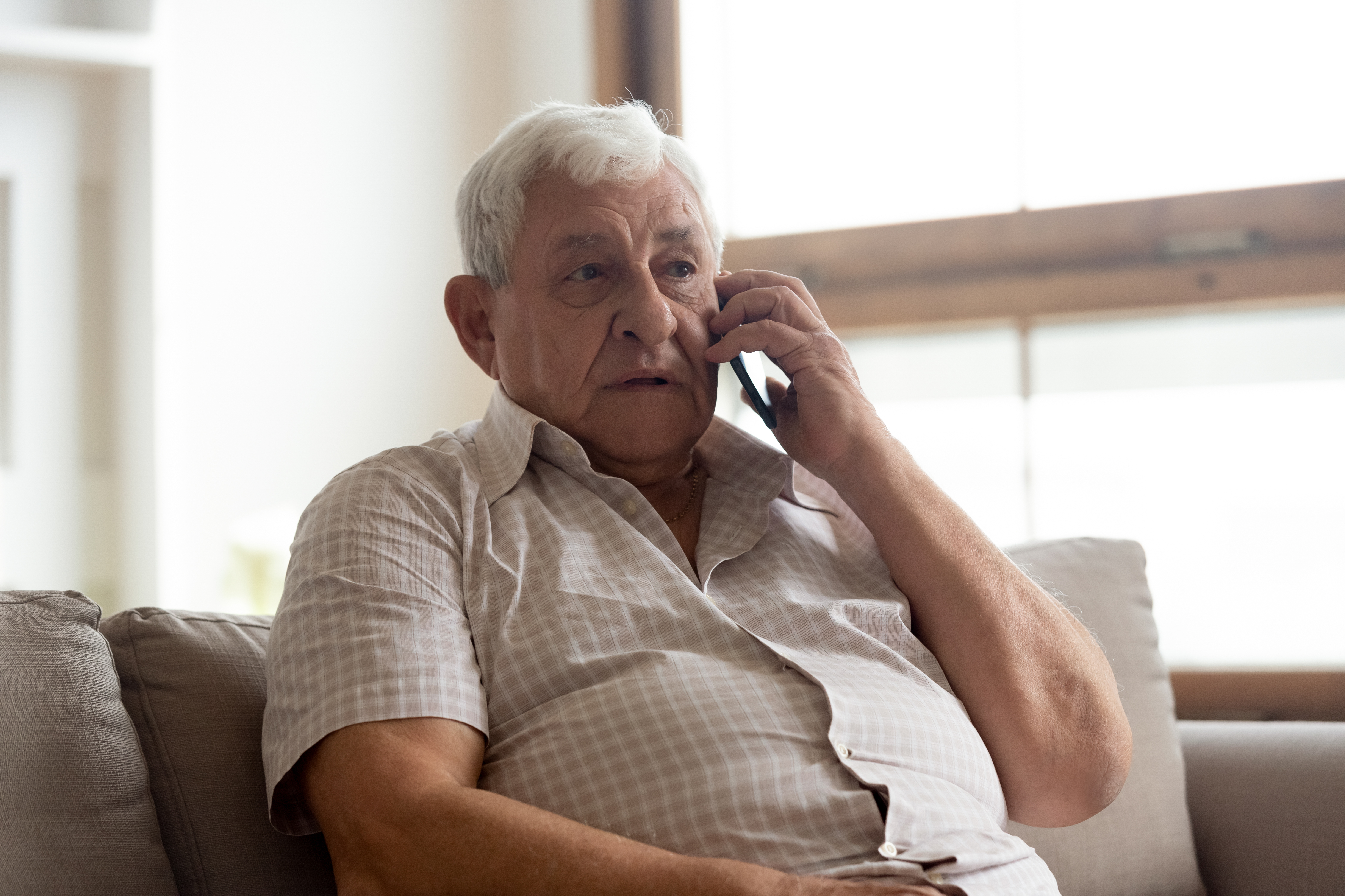 An older man talking on his phone | Source: Shutterstock